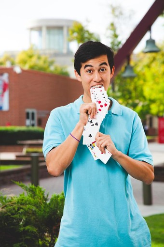 Brady Lee holding a deck of cards coming out of his mouth