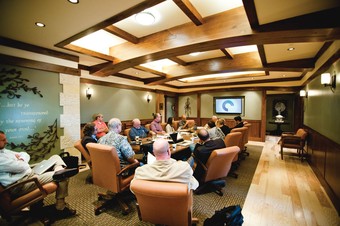 a room with people sitting around a table