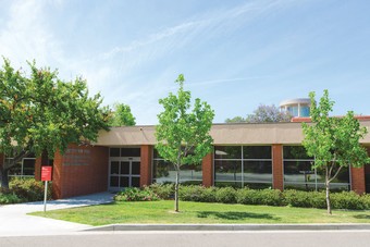 a brick building with trees in front