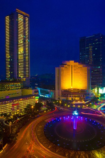 a roundabout with high-rise buildings at night