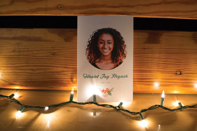 a card with a portrait of a woman in front of wood boards and string lights