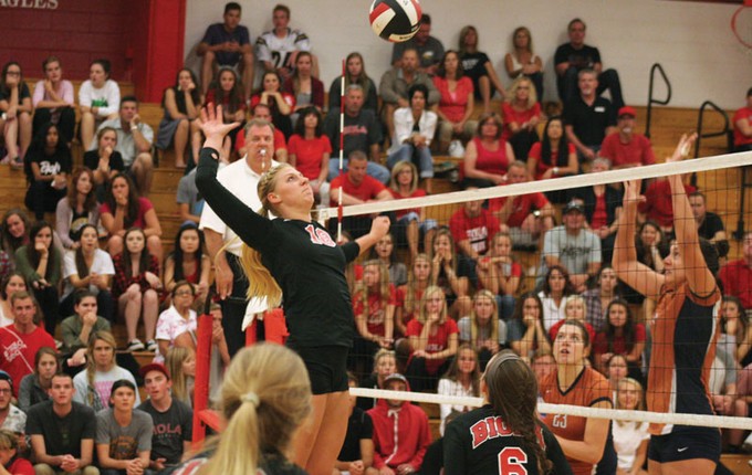 a volleyball player jumping to hit a ball