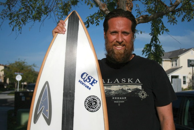 Daniel Felton holding a surfboard