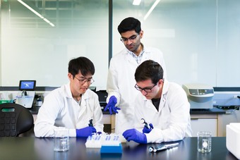 a professor and two students working in a lab