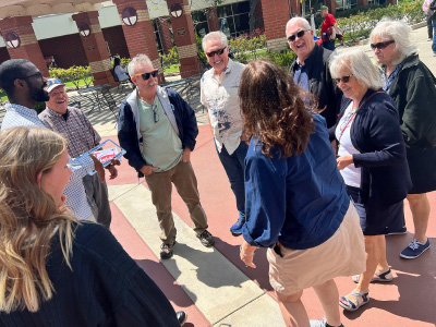 older people standing in a circle and talking