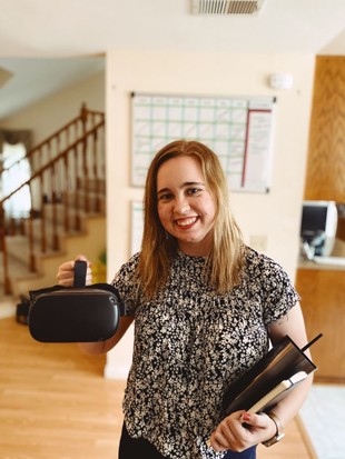 Megan Scott smiling and holding a VR headset