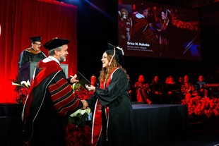 President Corey shaking a graduates hand